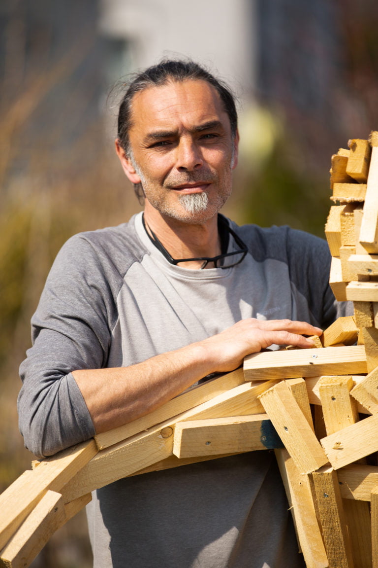 Mathes neben Figur aus Holzresten
